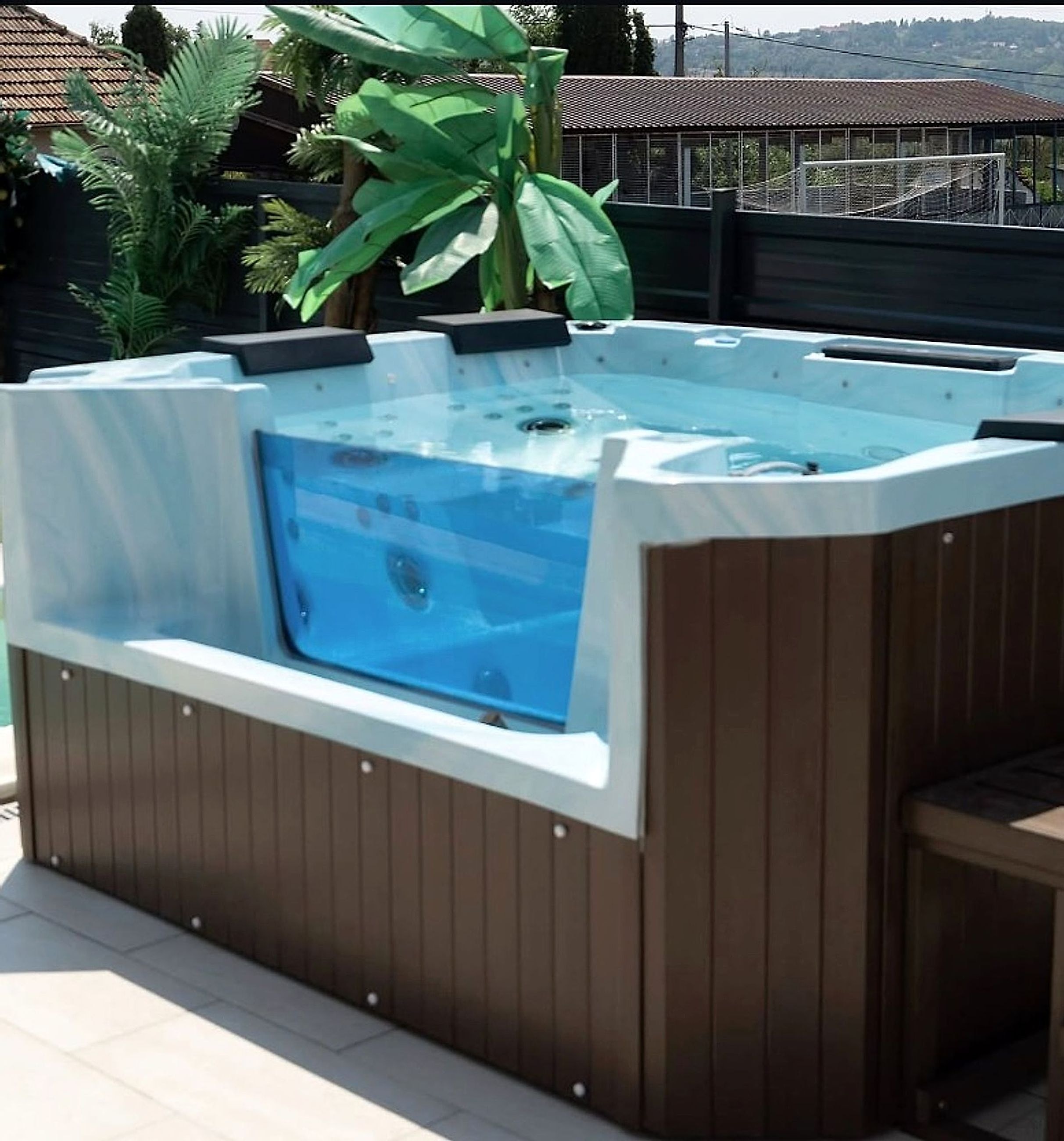Jacuzzi na terasi vikendice Bali Dream sa pogledom na dvorište sa palmama