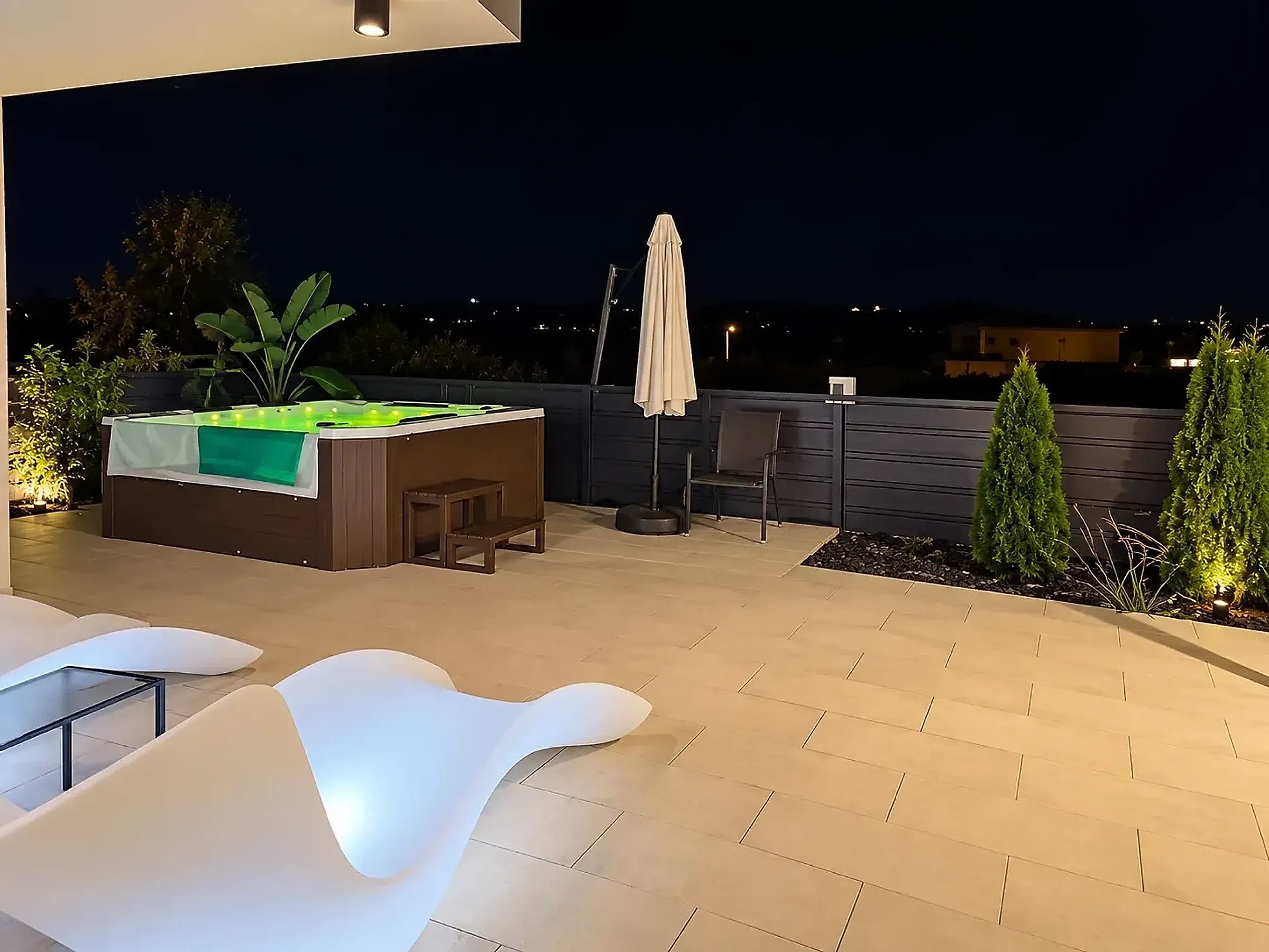 Osvetljen jacuzzi na terasi vikendice Bali Dream u večernjim satima